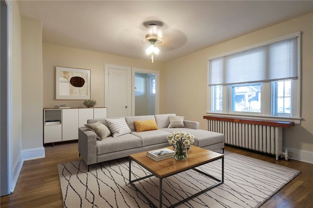 7447 Schoyer Ave, Swissvale, PA 15218 - living room featuring radiator, ceiling fan, dark wood-type flooring, and baseboards