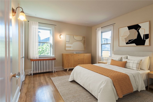 7447 Schoyer Ave, Swissvale, PA 15218 - bedroom featuring baseboards, wood finished floors, and radiator