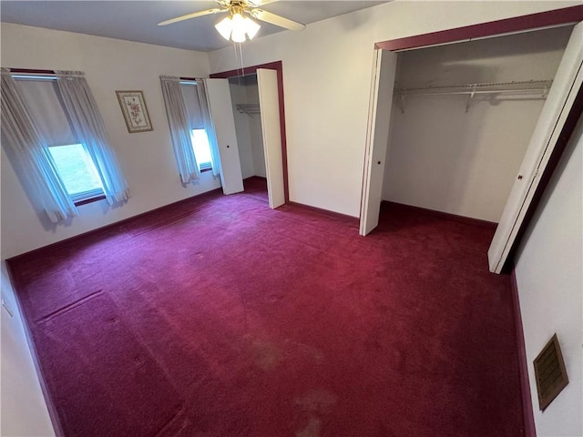966 Fayette City Rd, Fayette City, PA 15438 - unfurnished bedroom featuring multiple closets, visible vents, dark carpet, and ceiling fan