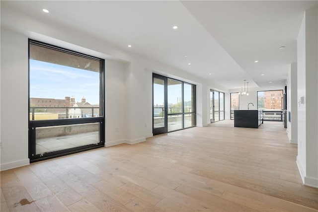 interior space featuring recessed lighting, light wood-style floors, and baseboards