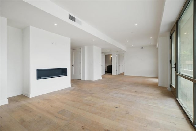 unfurnished living room with light wood-style flooring, a fireplace, visible vents, and recessed lighting