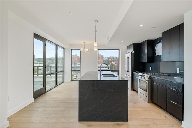 kitchen with stainless steel appliances, a city view, a sink, and dark cabinetry