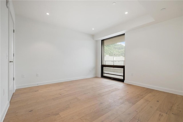 empty room with light wood-style floors, baseboards, and recessed lighting