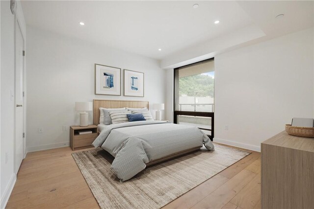 bedroom with light wood-style floors, baseboards, and recessed lighting