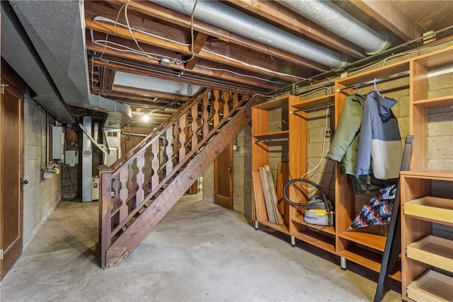unfinished basement with heating unit and stairway