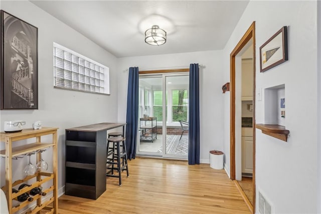 dining space with wood finished floors, baseboards, and visible vents