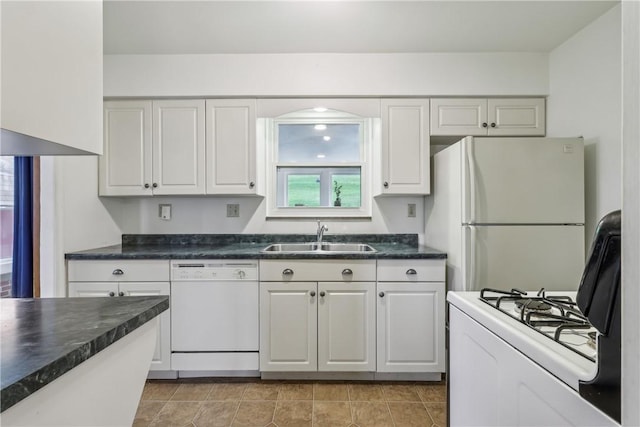 kitchen featuring a sink, white cabinets, dark countertops, and white appliances