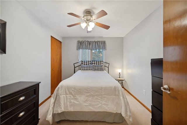 carpeted bedroom with a closet, baseboards, and ceiling fan