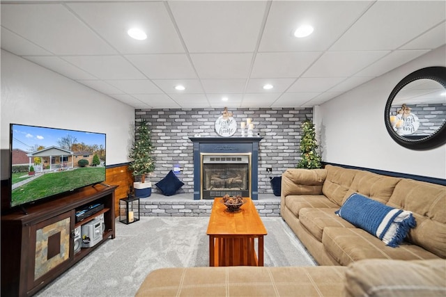 carpeted living area with a paneled ceiling, a fireplace, and recessed lighting