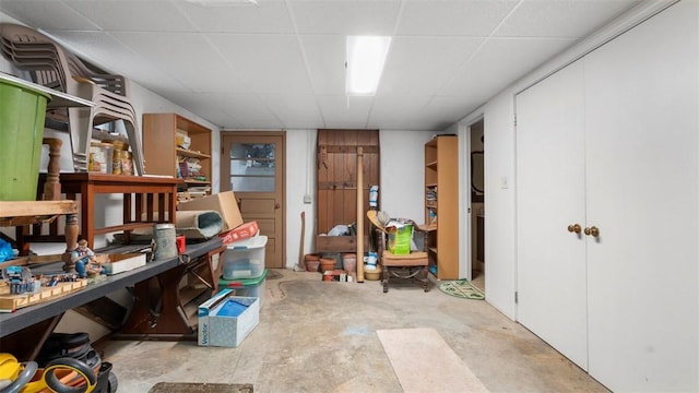 office space featuring concrete flooring, a paneled ceiling, and a workshop area