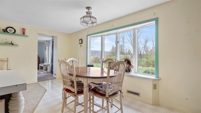dining space featuring visible vents and light floors