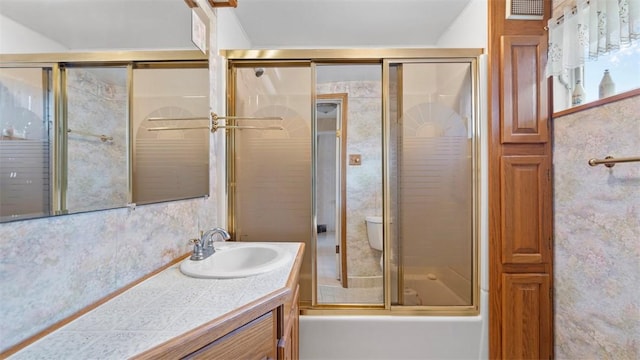 full bathroom featuring visible vents, toilet, vanity, and shower / bath combination with glass door