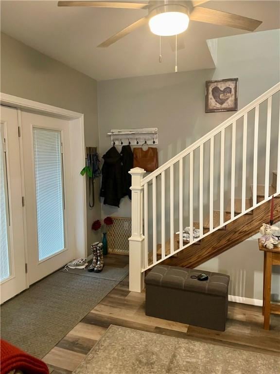 entryway with wood finished floors, stairs, and a ceiling fan