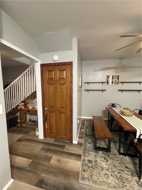 foyer entrance featuring wood finished floors, stairs, a ceiling fan, and baseboards