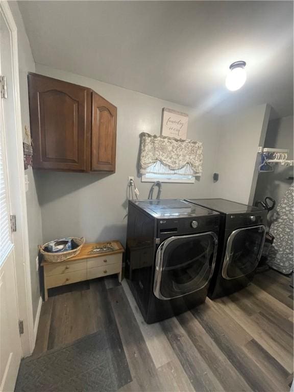 clothes washing area featuring wood finished floors, cabinet space, and independent washer and dryer