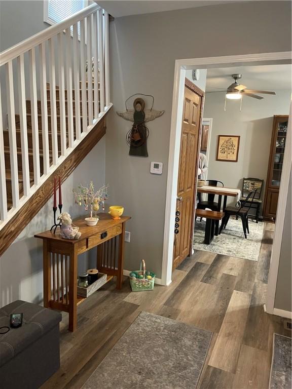 hall with wood finished floors, stairs, and baseboards