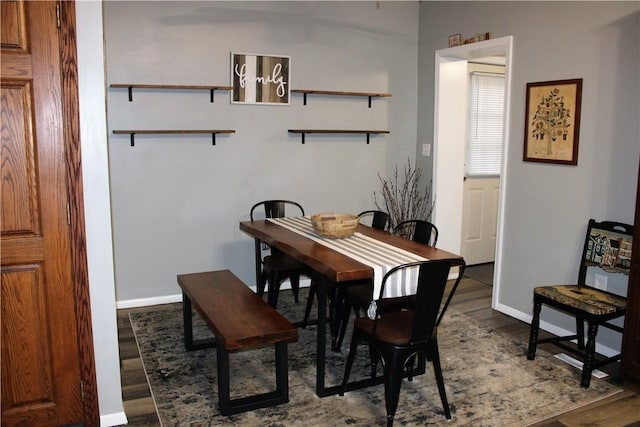 dining room featuring dark wood-style flooring and baseboards