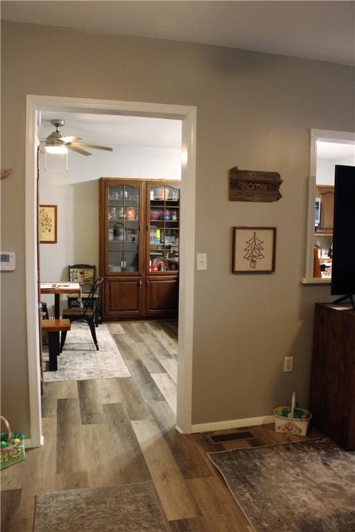 hallway featuring wood finished floors and baseboards