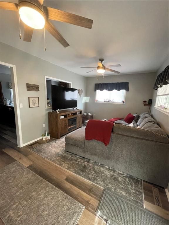living area featuring ceiling fan, wood finished floors, and baseboards