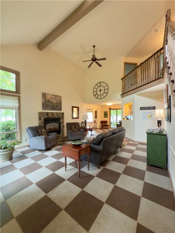 788 Latonka Dr, Coolspring Twp, PA 16137 - living room featuring a stone fireplace, healthy amount of natural light, high vaulted ceiling, beamed ceiling, and ceiling fan