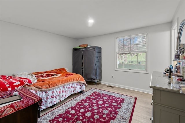 bedroom with light wood-style floors, baseboards, and visible vents