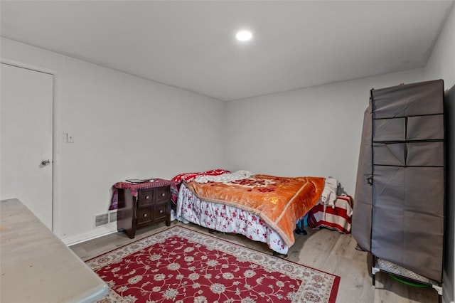 bedroom with recessed lighting, visible vents, and wood finished floors