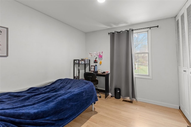 bedroom featuring wood finished floors, baseboards, and visible vents