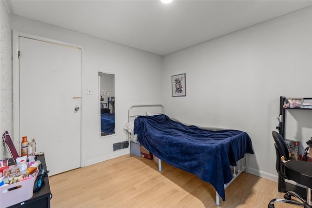 bedroom with visible vents, baseboards, and wood finished floors