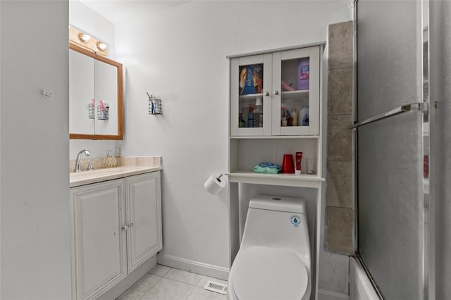 bathroom featuring vanity, visible vents, toilet, tile patterned floors, and baseboards