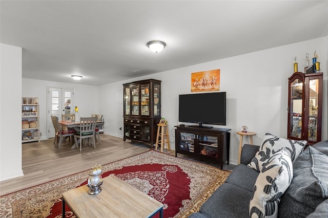 living area with baseboards and wood finished floors