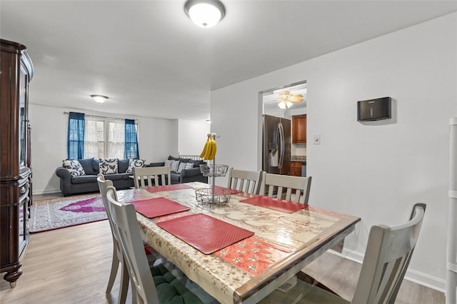 dining area featuring light wood-type flooring and baseboards