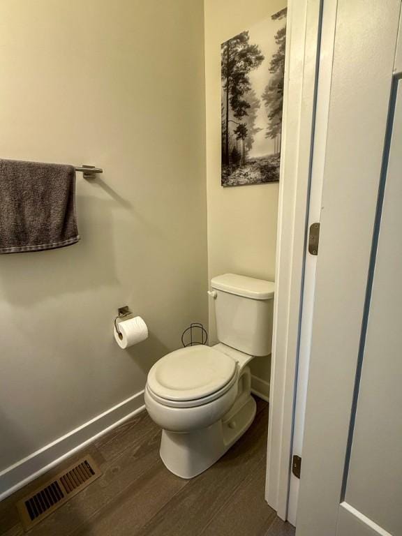 bathroom with wood finished floors, visible vents, toilet, and baseboards