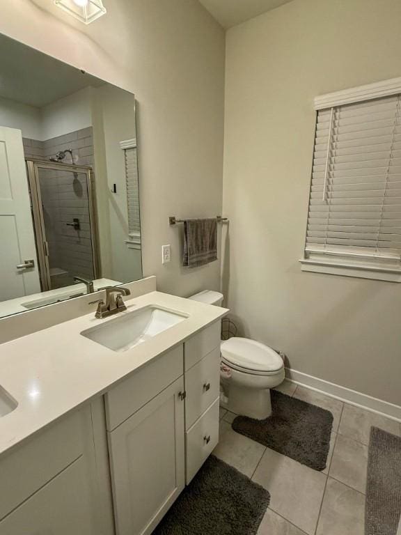 full bathroom with a sink, a shower stall, toilet, double vanity, and tile patterned flooring