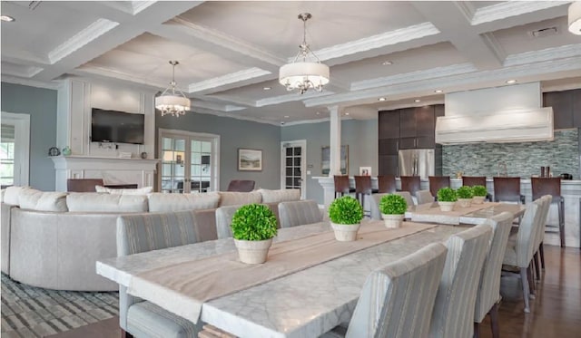 dining area with beamed ceiling, coffered ceiling, and a notable chandelier