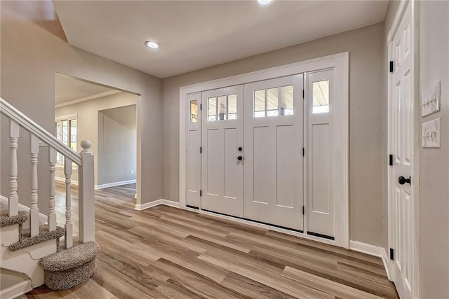 foyer featuring recessed lighting, stairway, light wood-style floors, and baseboards