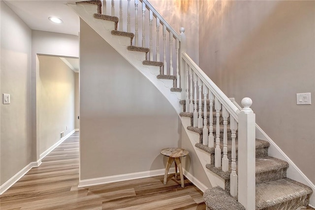 stairs with visible vents, baseboards, and wood finished floors