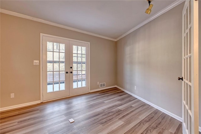 interior space featuring crown molding, french doors, wood finished floors, and baseboards