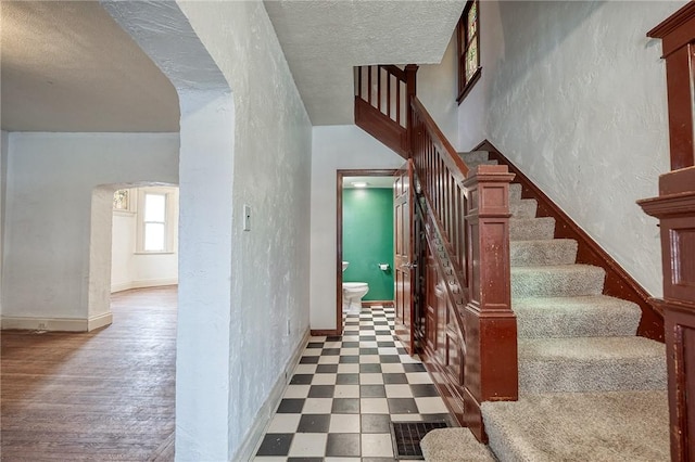 1223 Chelton Ave, Brookline, PA 15226 - staircase featuring a textured wall, baseboards, visible vents, and arched walkways