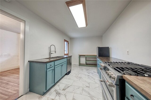 1223 Chelton Ave, Brookline, PA 15226 - kitchen with marble finish floor, stainless steel appliances, a sink, butcher block counters, and blue cabinetry
