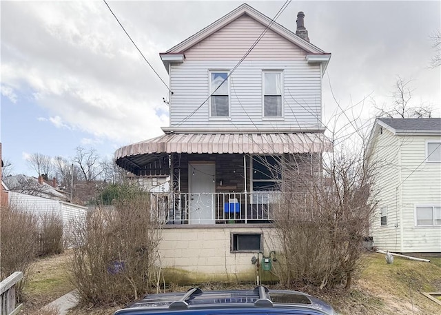 view of front of property with a chimney and covered porch
