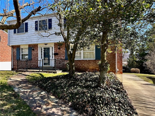 colonial-style house featuring brick siding