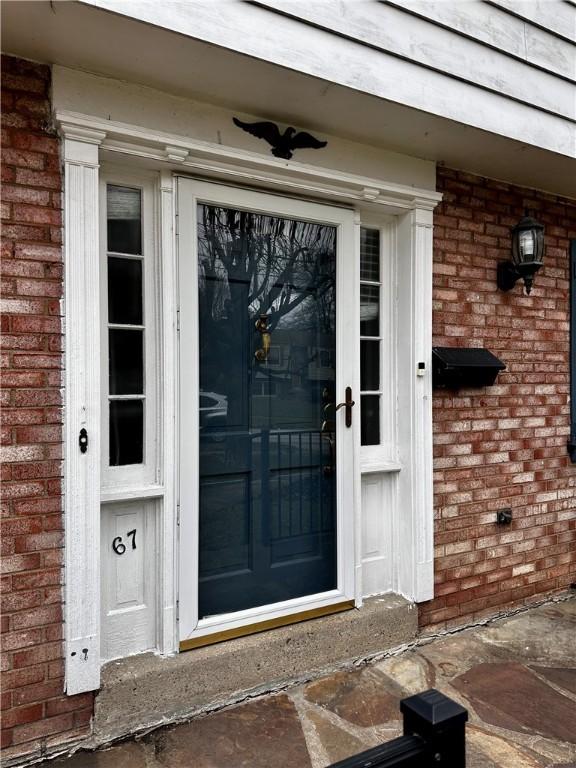 view of exterior entry featuring brick siding