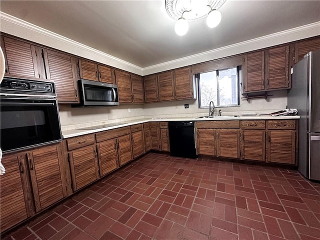 kitchen with brick patterned floor, ornamental molding, black appliances, light countertops, and a sink