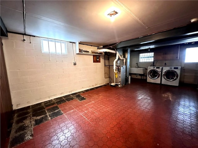 basement with independent washer and dryer, a sink, heating unit, and dark floors