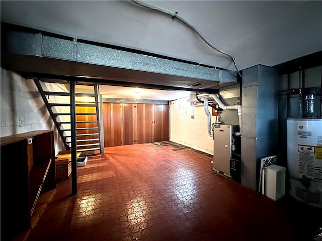 finished below grade area with stairs, water heater, and concrete block wall