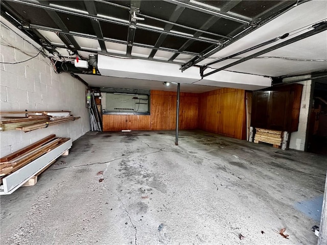 garage featuring a garage door opener and concrete block wall