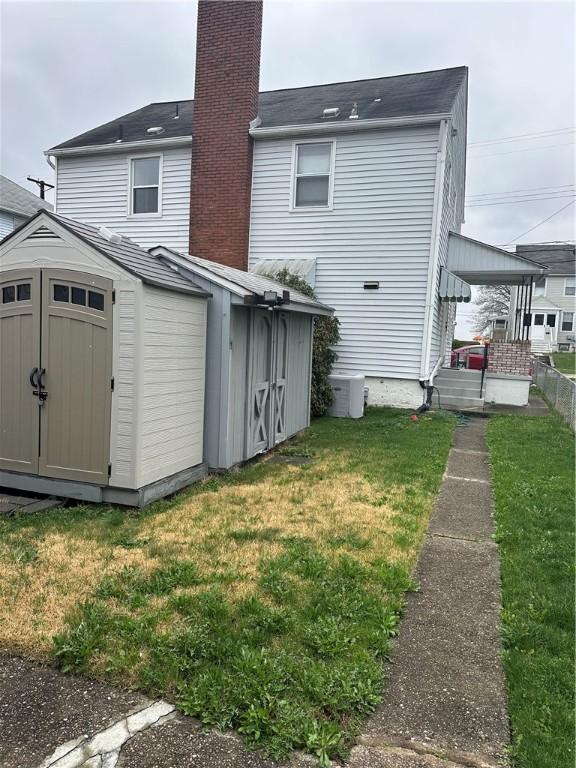 555 Farnsworth Ave, Clairton, PA 15025 - back of house featuring a yard, an outdoor structure, a shed, and a chimney