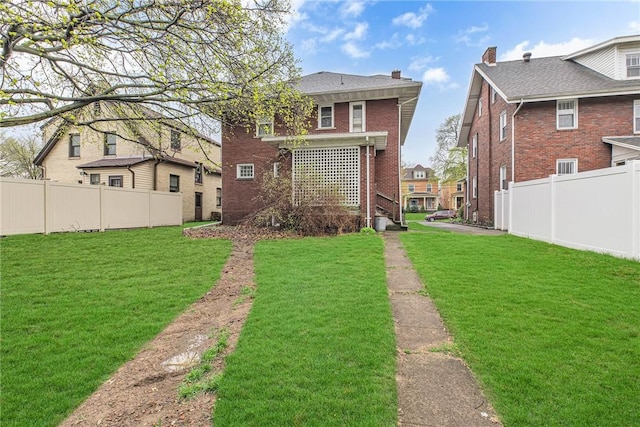 338 4th St, Beaver, PA 15009 - back of property with brick siding, fence private yard, and a lawn