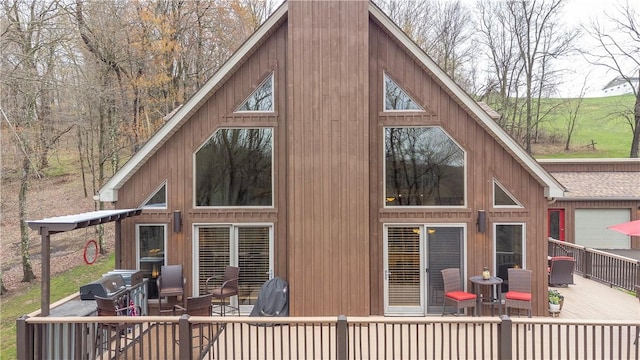 rear view of house with outdoor dining space and a deck