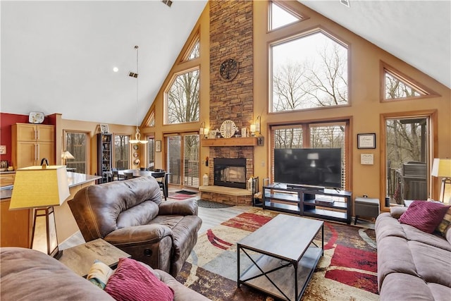 living room featuring visible vents, high vaulted ceiling, light wood finished floors, and a fireplace